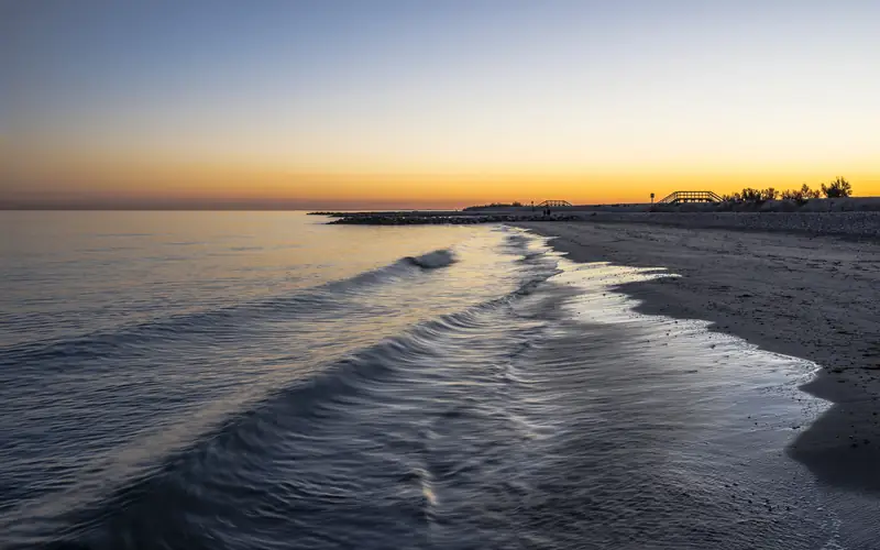 Gentle waves on an empty beach at sunset
