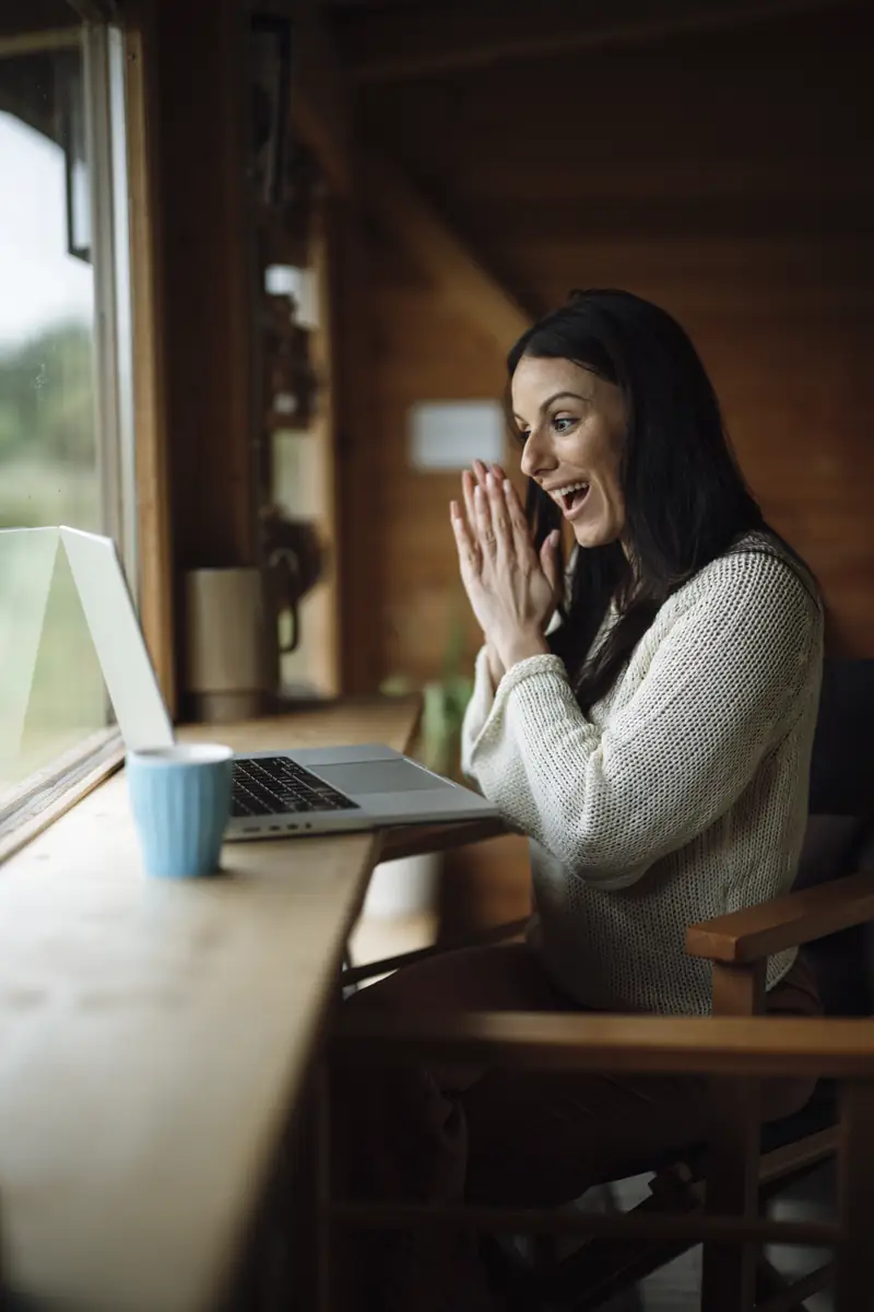 A woman smiling during a video call on a laptop
